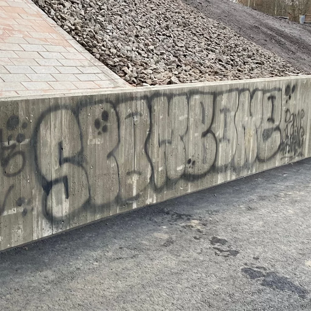 Betonimuuri jossa on musta graffiti