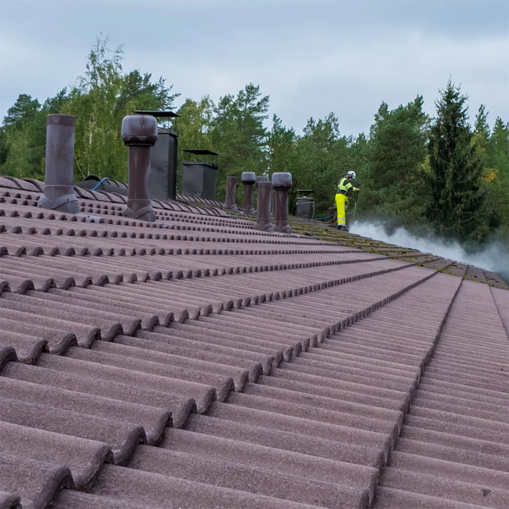 Rivitalon katto, joka on puoliksi puhdistettu ja jota Bintan työntekijä on juuri pesemässä