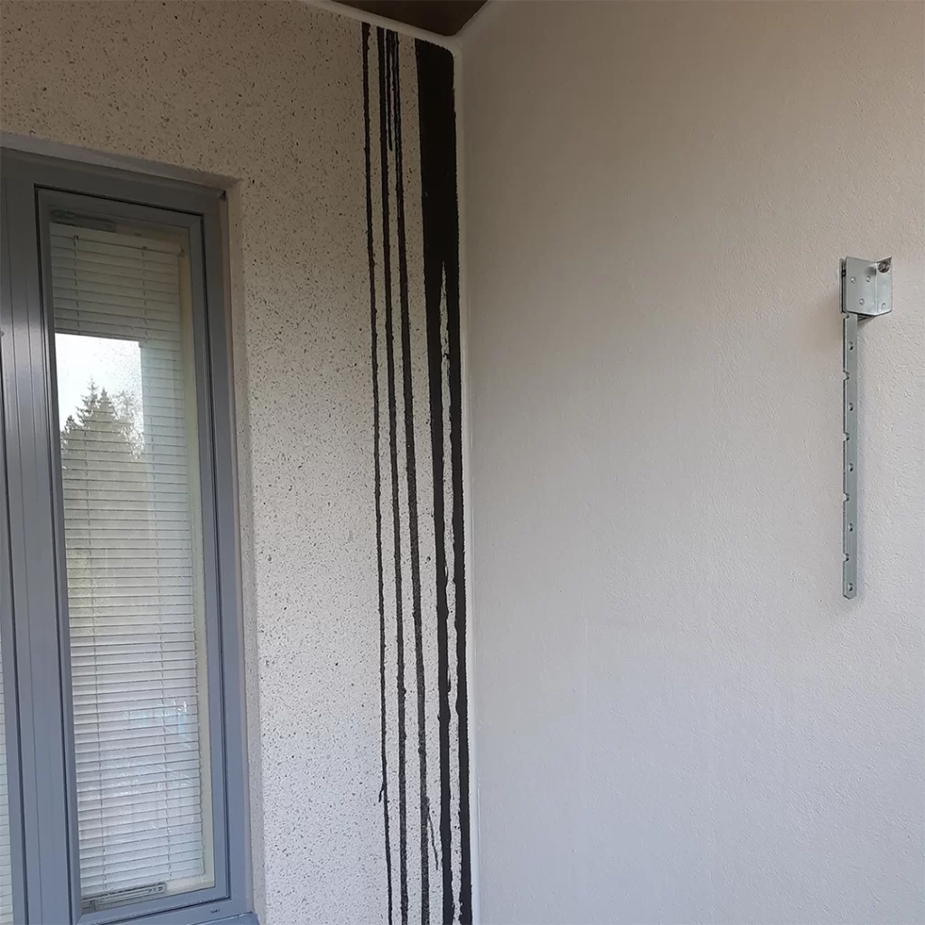 Kerrostalon seinässä on mustia valumajälkiä