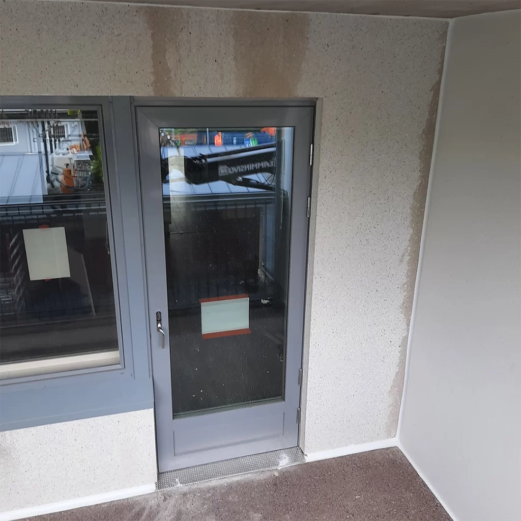 Kerrostalon seinässä parvekkeen oven yläpuolella on valumajälkiä